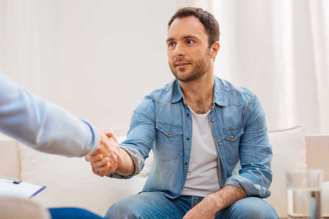 Man im Gespräch auf Augenhöhe mit anderem Mann